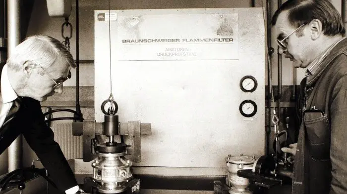 Historical image of engineers working on innovative flame filter technology, showcasing advancements in safety and engineering.